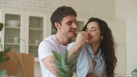 smiling man and woman eating strawberry