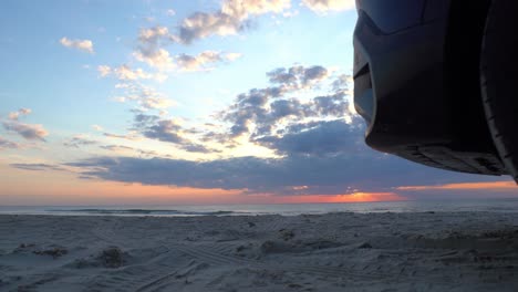 Slider-shot-of-sunset-over-the-se-with-a-car-on-the-foreground