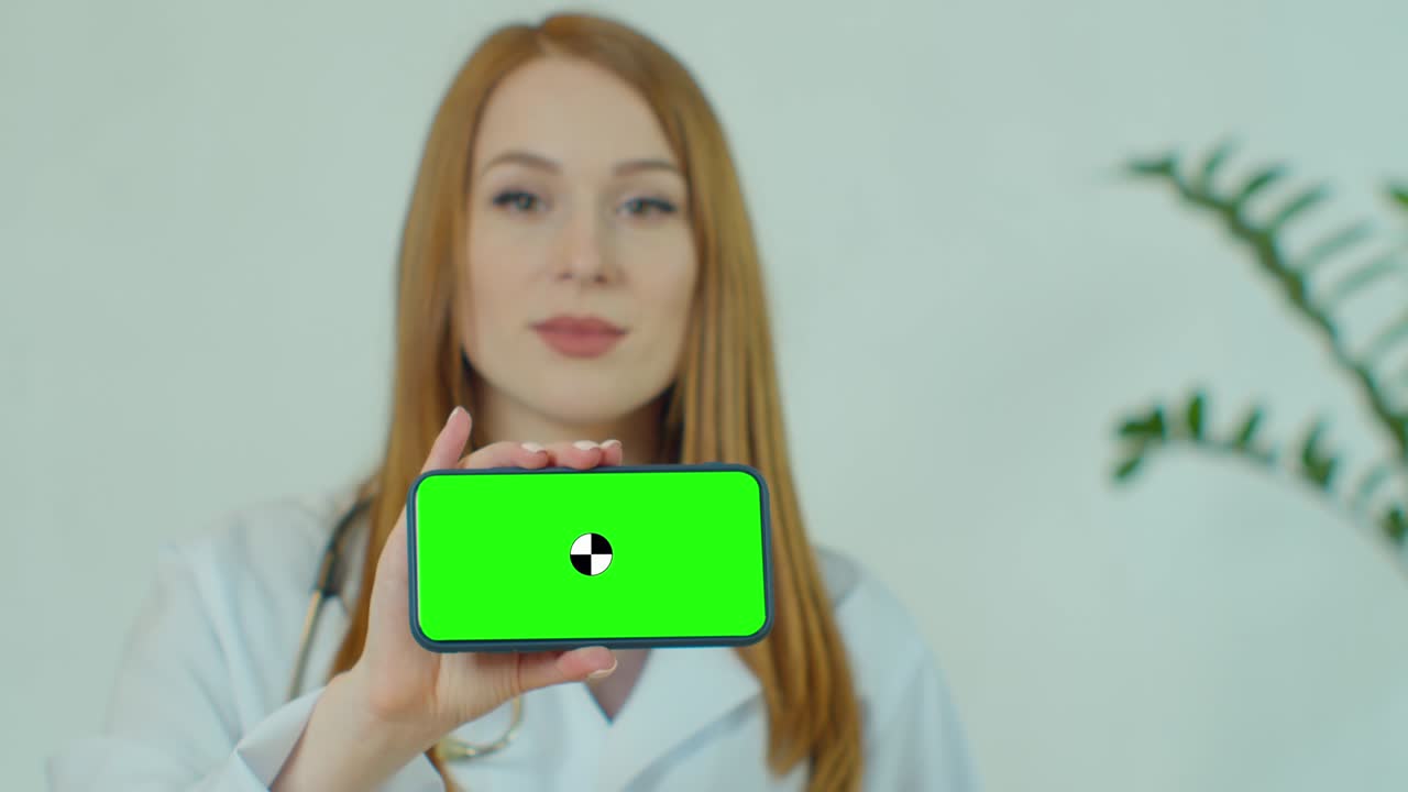 mujer profesional médica mostrando teléfono inteligente móvil con pantalla verde. mujer médico sosteniendo teléfono con pantalla verde hasta la cámara. pantalla verde en el teléfono sostenido por científico.