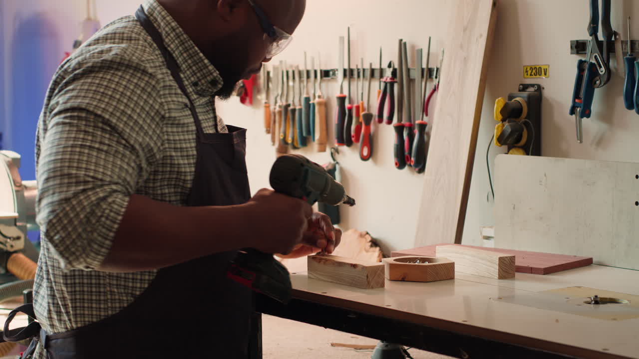 artesano sumerge tornillos en un bloque de madera con una herramienta eléctrica
