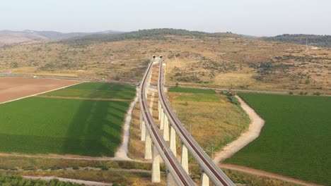 aerial view of a train line through a landscape with tunnels and vineyards