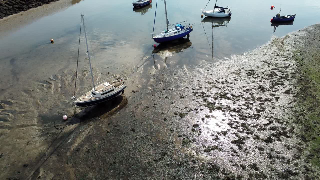 antena birdseye por encima de los barcos en la reluciente playa de arena con motivos soleados en marea baja marina tirar hacia atrás inclinar hasta el horizonte