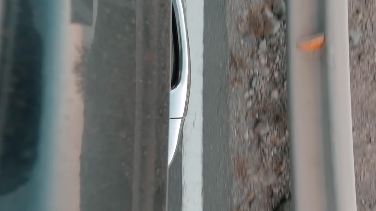 해안 근처의 높은 도로를 지나가는 느린 동작으로 외부에서 차의 문 손잡이