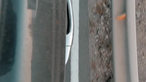 Door-handle-of-car-from-the-outside,-in-slow-motion-passing-by-a-high-road-near-the-coast