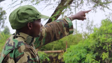 officer showing signs to soldiers in forest, on a overcast day, in africa