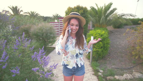 woman talking on phone in summer garden