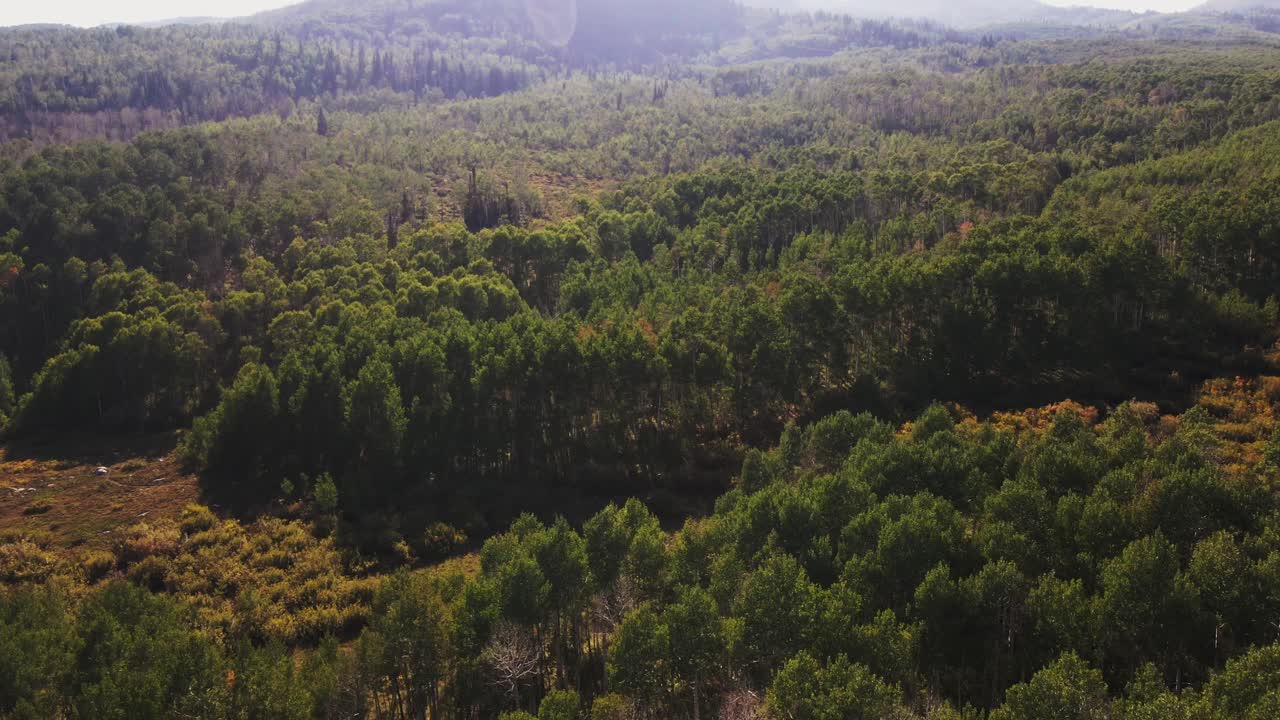 dolly aéreo hacia adelante hacia las montañas retroiluminadas de guardsman pass, utah