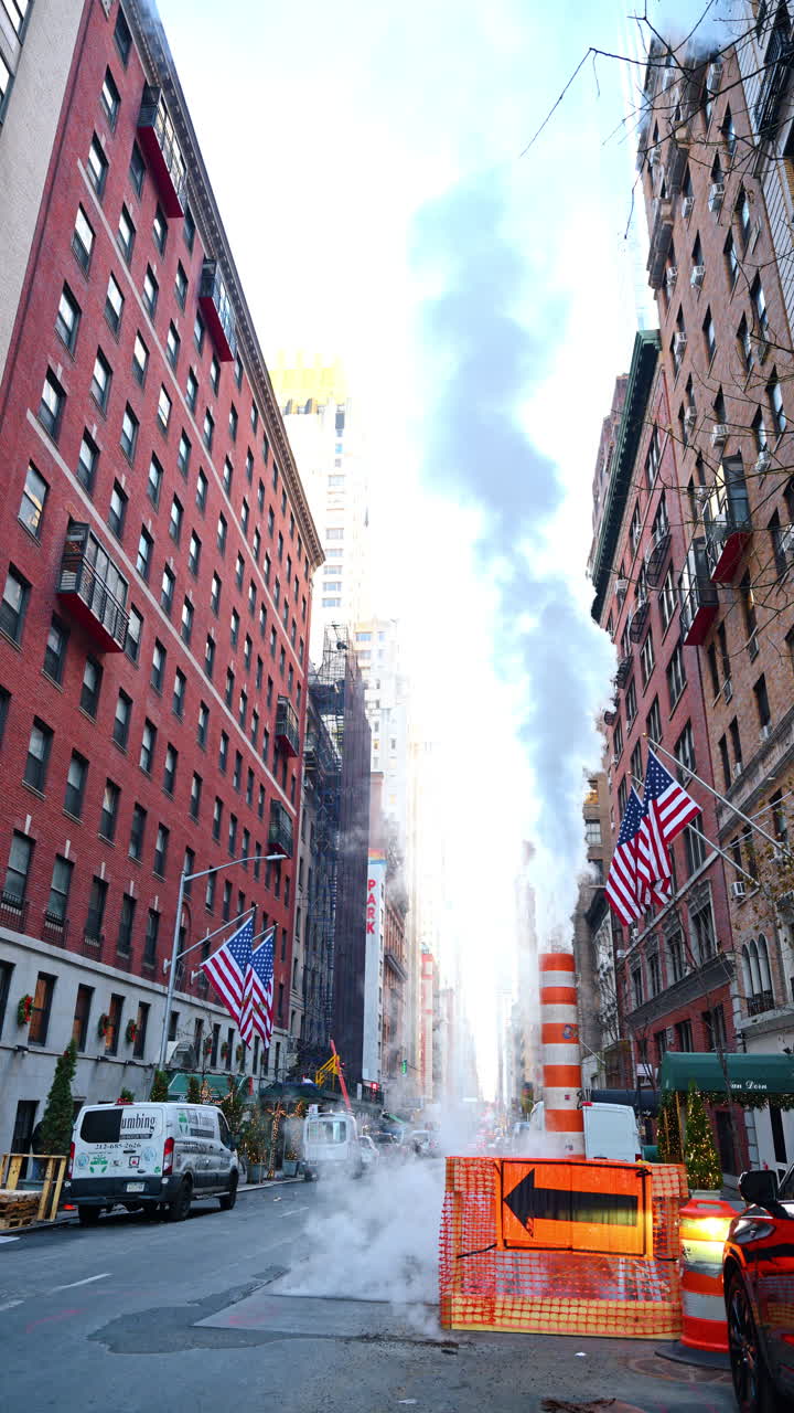 New York, USA, 18 dicembre 2025: Vapore sale da un tubo per strada a New York, USA. Vista dal basso degli edifici a più piani in mattoni sullo sfondo. Video verticale