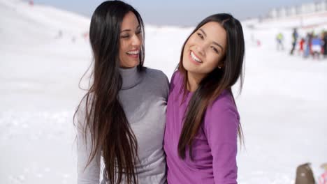 mujeres jóvenes riendo vivazmente en una estación de esquí