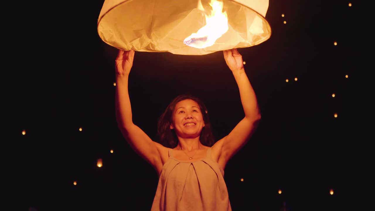 하늘의 등불을 방출하는 아시아 여성