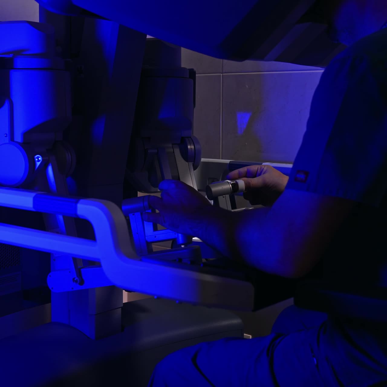Experienced male surgeon works on innovative robotic equipment. Doctor leaves the handles continuing to look at binoculars
