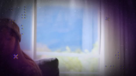 woman standing by window, presenting animated technology dashboard over knit sweater and curtains