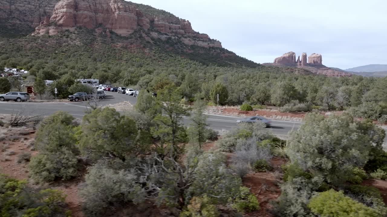 애리조나 주 세도나의 레드 록 산맥과 버트 (red rock mountains and buttes in sedona, arizona) 에서 드론 비디오가 차와 함께 으로 움직이고 있습니다.