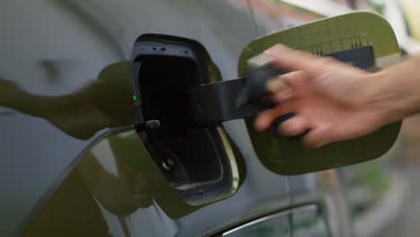 Close Up Of Driver Opening Ev Car Charging Port Flap To Charge Battery