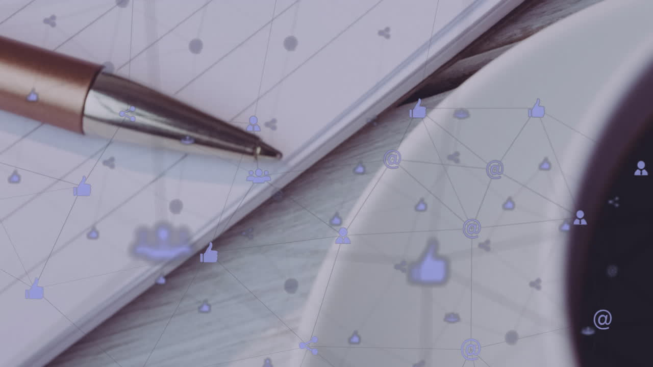 Metallic ballpoint pen and notebook being animated on desk, showing floating social media icons