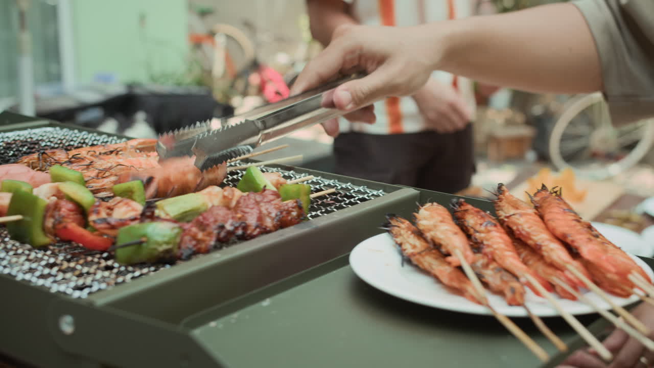 Hands of People Cooking Skewers and Sausages on Grill