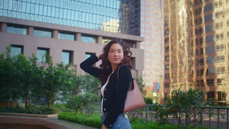 asian girl posing in front skyscraper. stylish woman smiling on camera on street