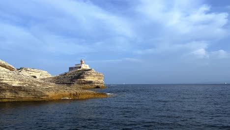 Faro-Madonnetta-Encaramado-En-Un-Acantilado-A-Lo-Largo-De-La-Costa-Sur-De-La-Isla-De-Córcega-En-Francia-Visto-Desde-Un-Velero-1