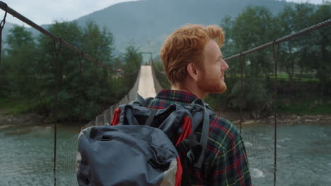 excited traveler enjoy landscape mountains. closeup joyful hiker walk on bridge.