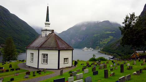 tiny, quaint geiranger church and cemetery overlooking beautiful geiranger fjord in norway and cruise ship 4k prorezhq