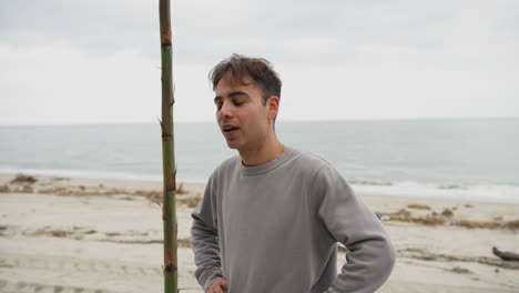 enthusiastic guy after finishing his work at the beach smiles