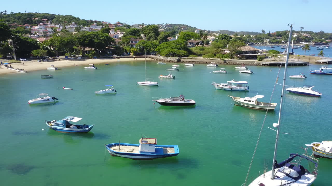 Drone flight over beach with fishing boats in Buzios, Brazil