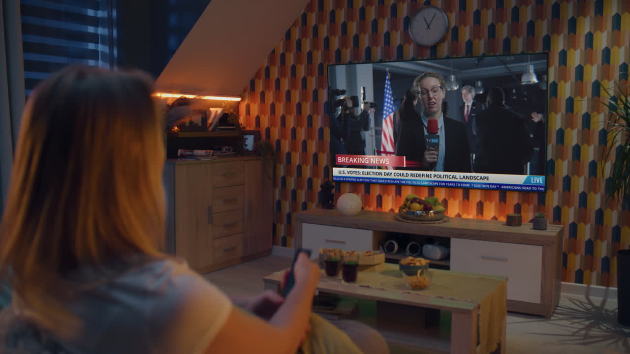 mujer viendo las noticias de las elecciones en la televisión en casa