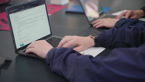 primer plano de la computadora portátil de desplazamiento de la mano del estudiante en la escuela, 4k