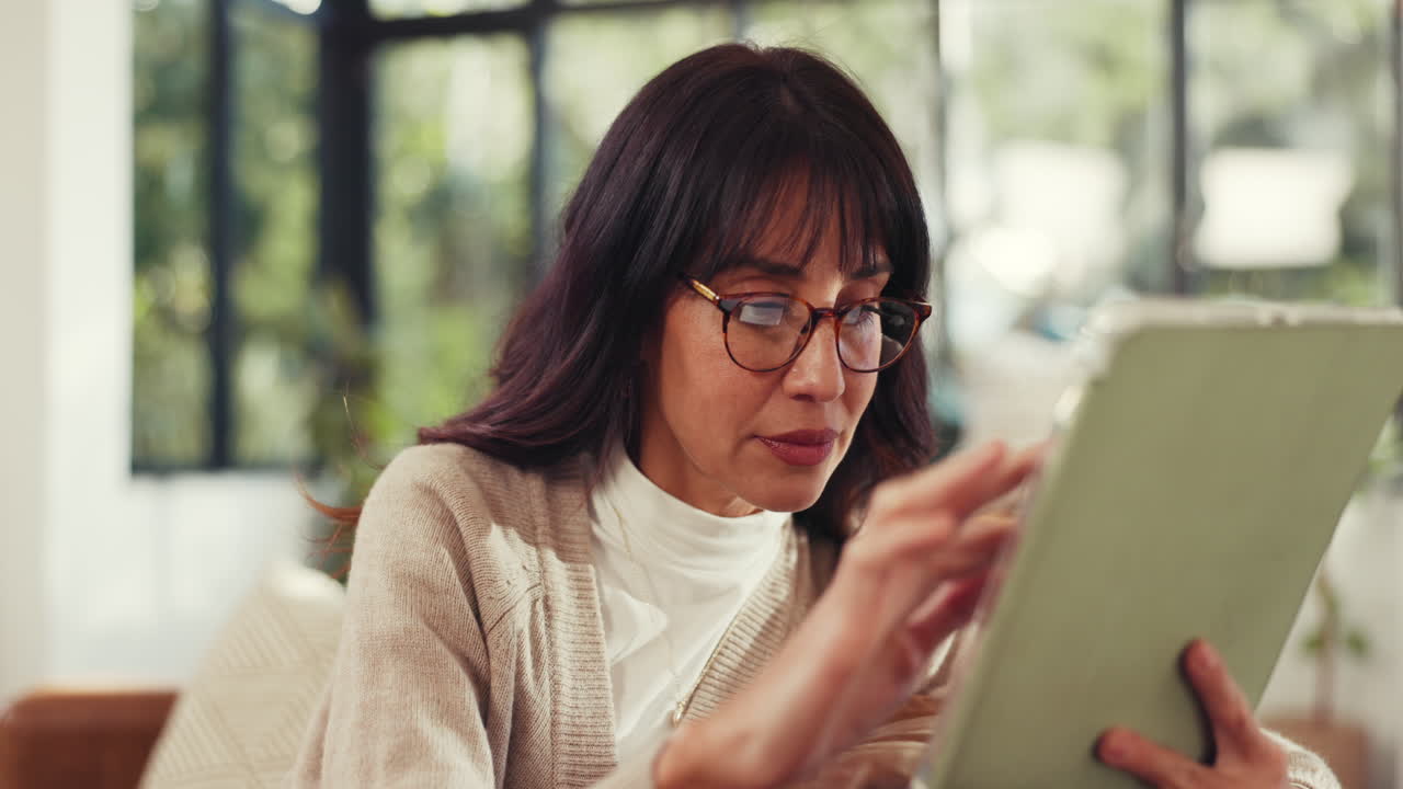 屋内でタブレットを読む女性