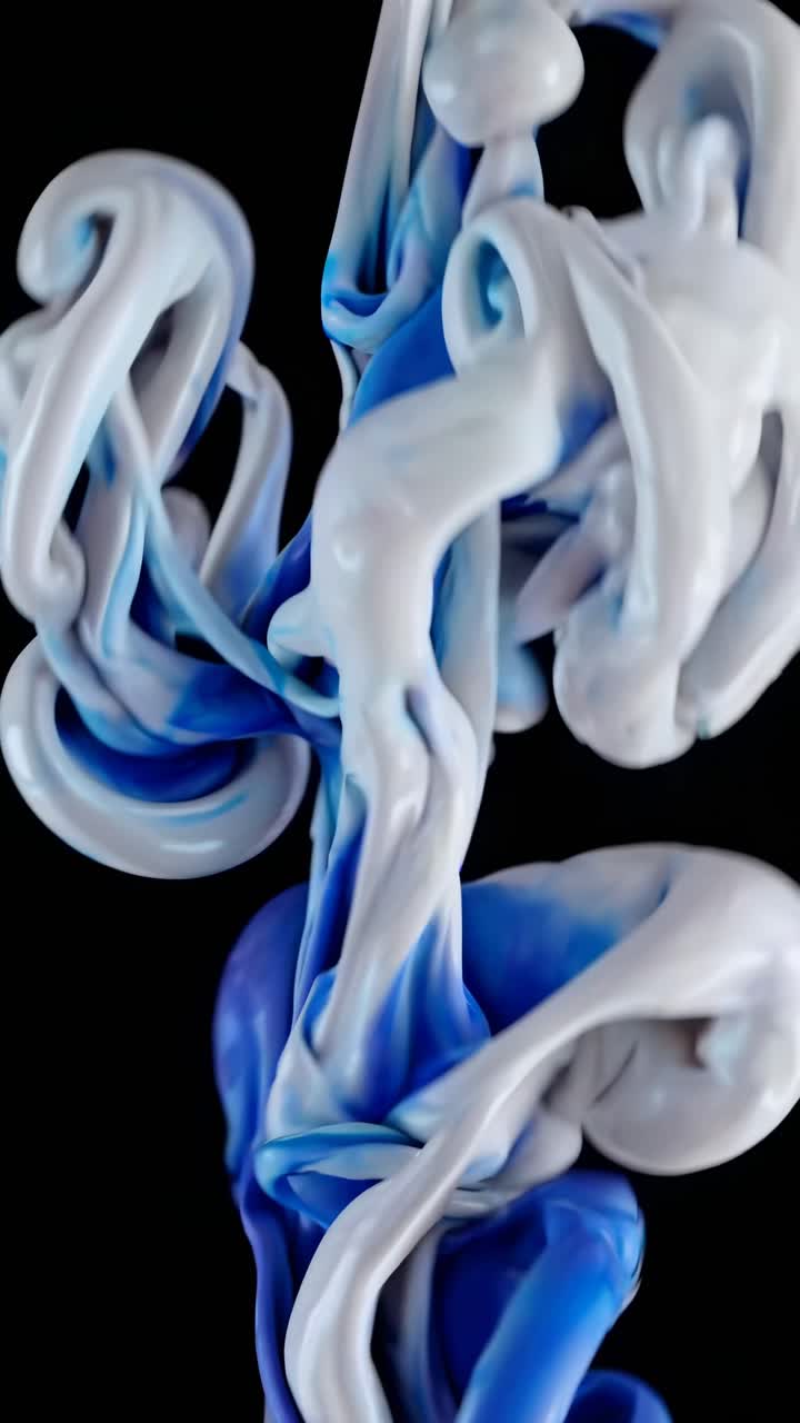 Video ravvicinato di vernice blu e bianca che si mescola nell'acqua, ripreso da un angolo basso
