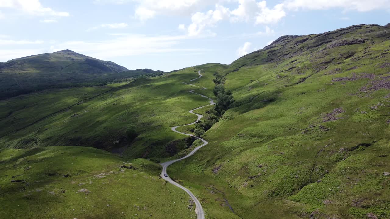 Car descending down Hardknott Pass Mountain Road in Lake District