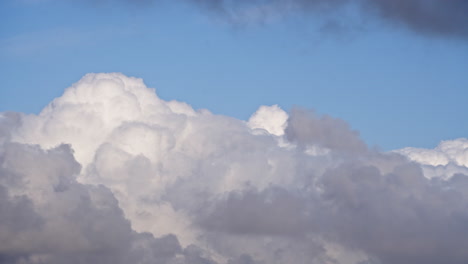 timelapse of clouds blooming and changing shape in blue sky, telephoto view