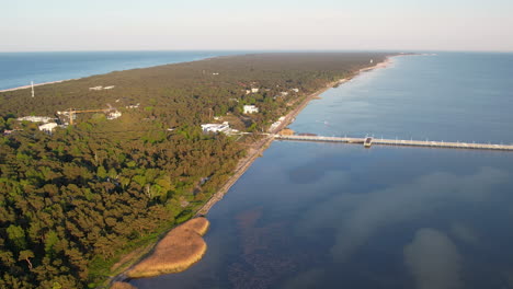 Aerial-arc-over-Jurata-coastline-and-wooden-pier-on-Hel-Peninsula,-Poland