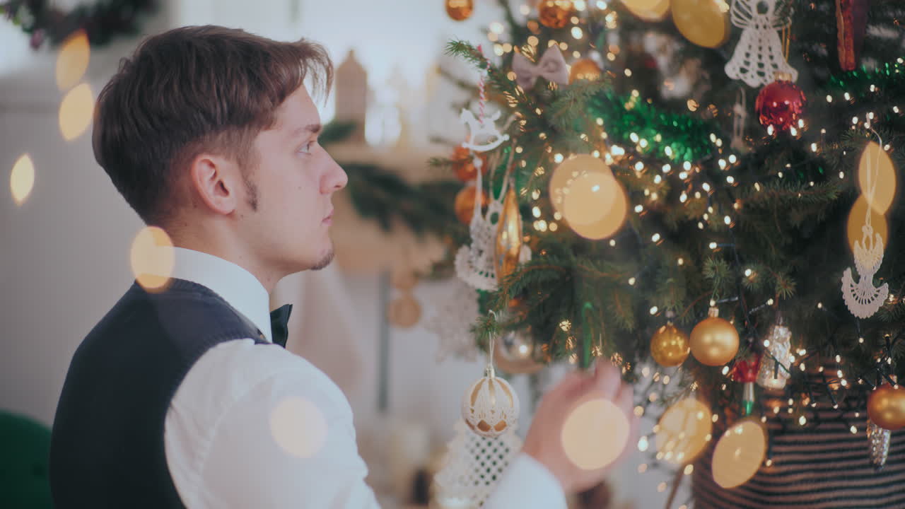 joven colgando joyas en el árbol de navidad en casa