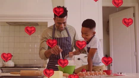 red heart balloons animation over father and son baking in kitchen