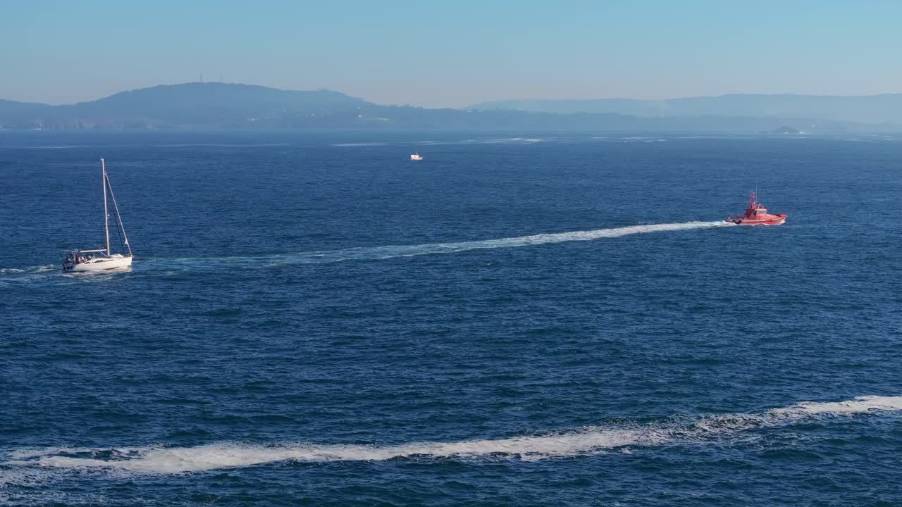 Lifeboat And Yacht Cruising In The Ocean With Calm Waves At Summer. - aerial shot