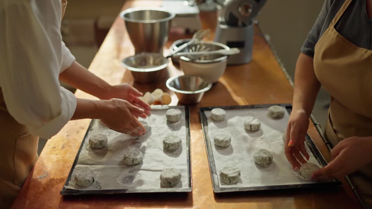 Two people are baking cookies in a kitchen