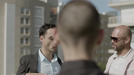 handheld shot of male coworkers talking during business party