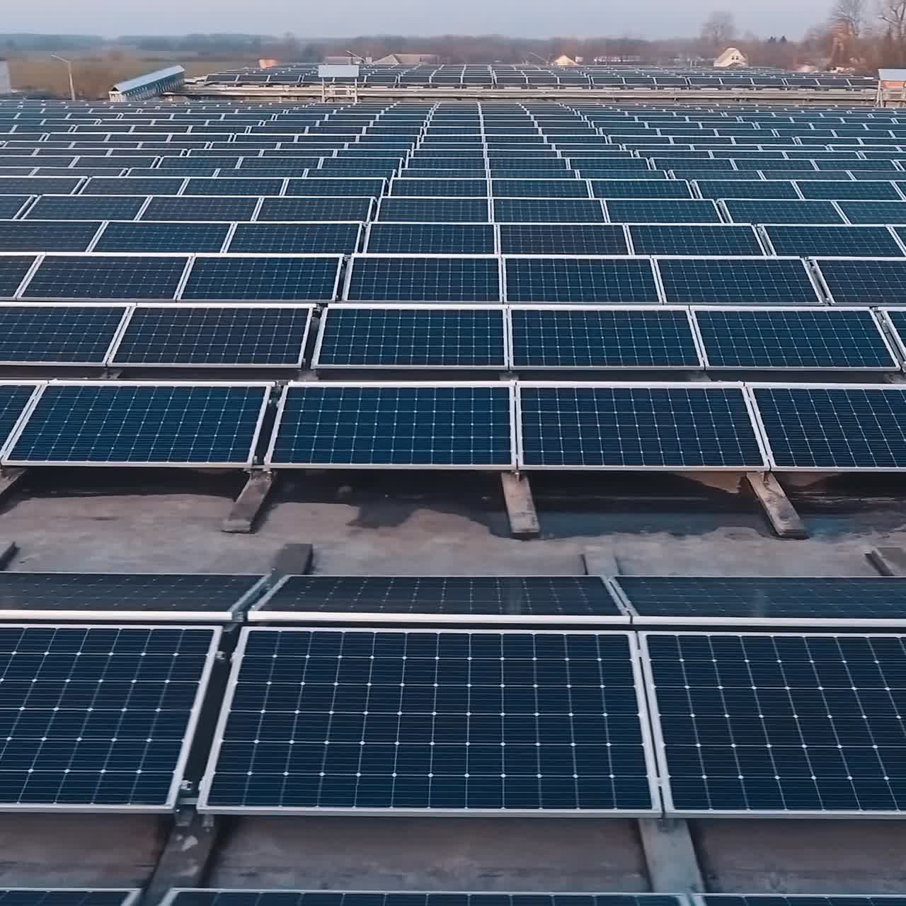 Rows of photovoltaic panels on a flat roof. Huge territory on the top of the building with solar panels. Alternative source of clean energy from the sun. Aerial view.