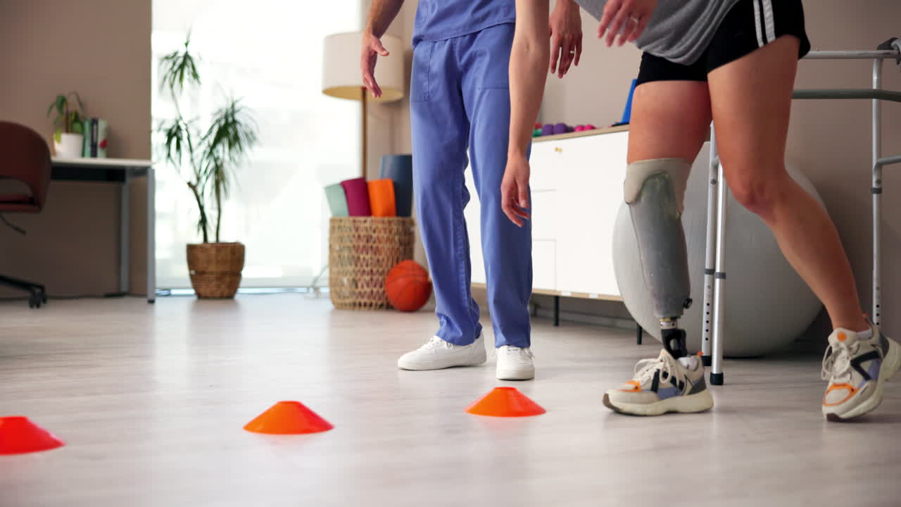 terapeuta físico ayudando a un paciente con un ejercicio de pierna protésica con conos
