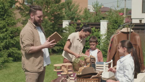 neighbors choosing items at garage sale