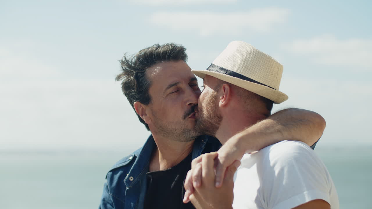 medium shot of gay couple kissing outdoors in windy weather