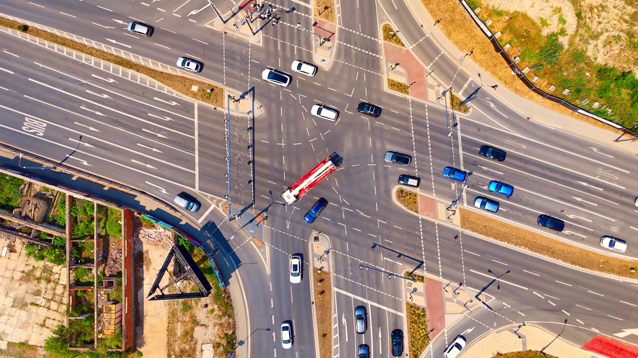 City intersection traffic on multi lane roads, Bratislava, Slovakia. Overhead drone perspective of vehicles driving through asphalt crossroads.