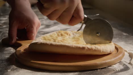 Cutting-Imeruli-khachapuri-into-slices-on-wooden-board,-closeup