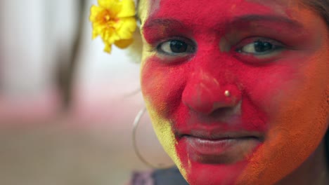 indian women close-up of face smeared with bright holi colors