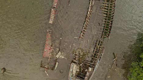 Aerial-top-down-shot-over-boat-wreck-skeleton-along-Surigao-Del-Norte-coast,-Philippines-at-daytime