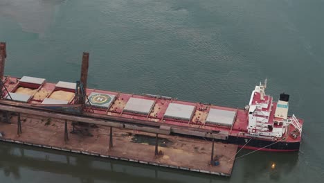 Large-barge-with-bulk-cargo-docked-in-port-of-São-Francisco-do-Sul,-Brazil