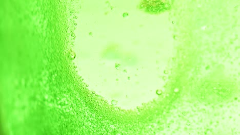 macro-shot-of-bright-green-water-with-many-sparkling-bubbles-leaving-a-little-spot-without-bubbles