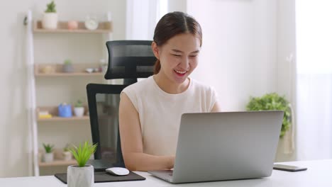 young asian woman working, shopping online,  with laptop computer at home