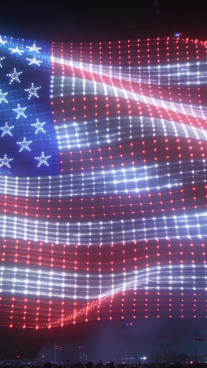 Vertical video: Signal starting, American-flag drone formation pulsing and rippling for night show